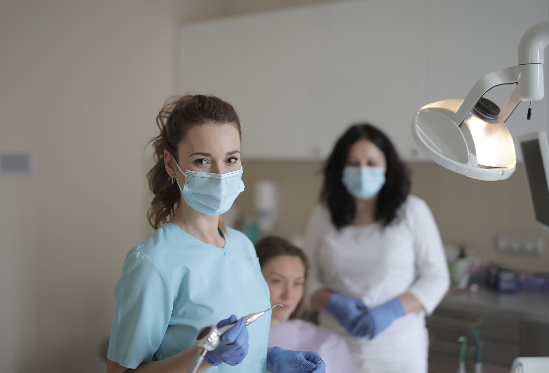 Equipo dental con mascarillas preparando una consulta en clínica moderna