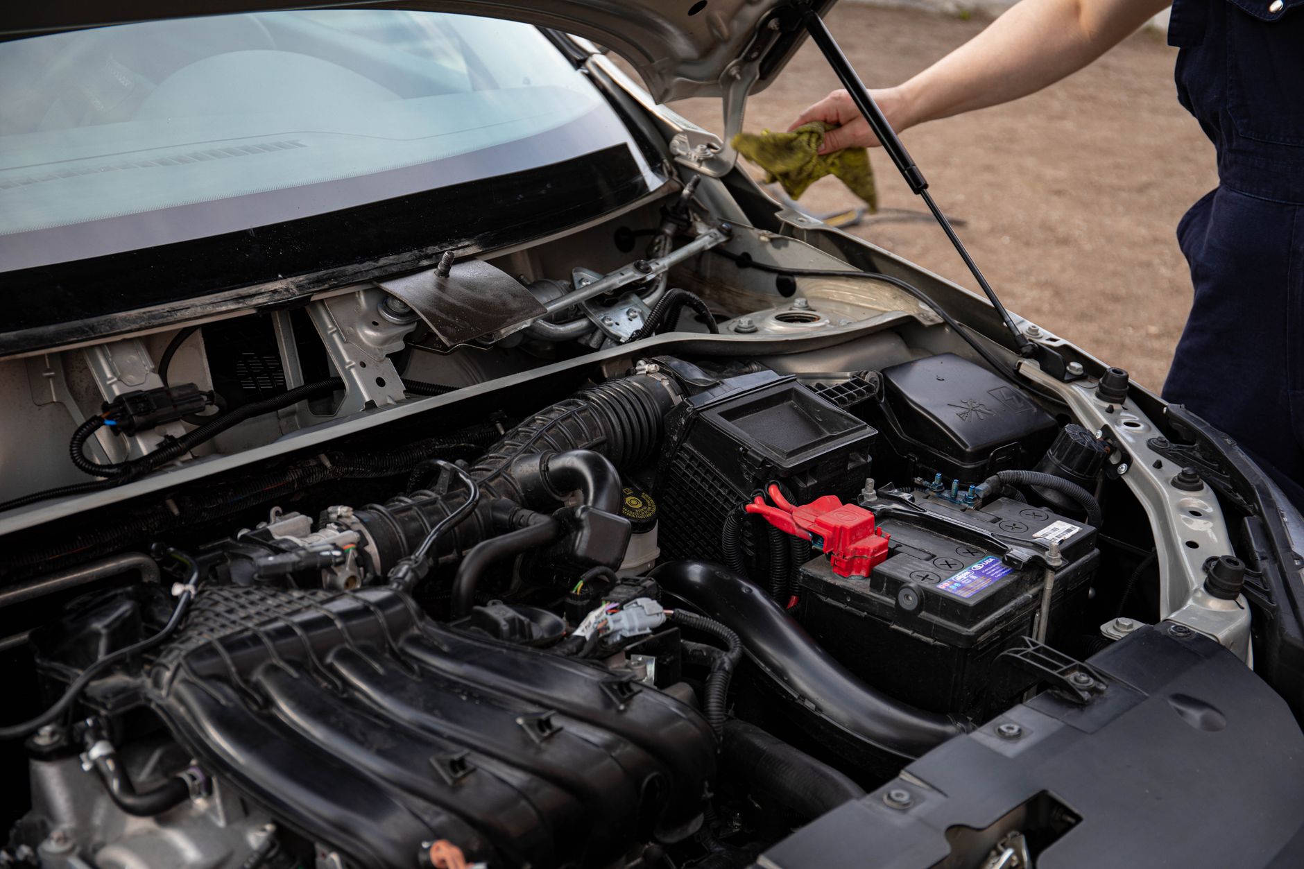 Mecánico revisando el motor de un vehículo durante un mantenimiento de rutina en el taller