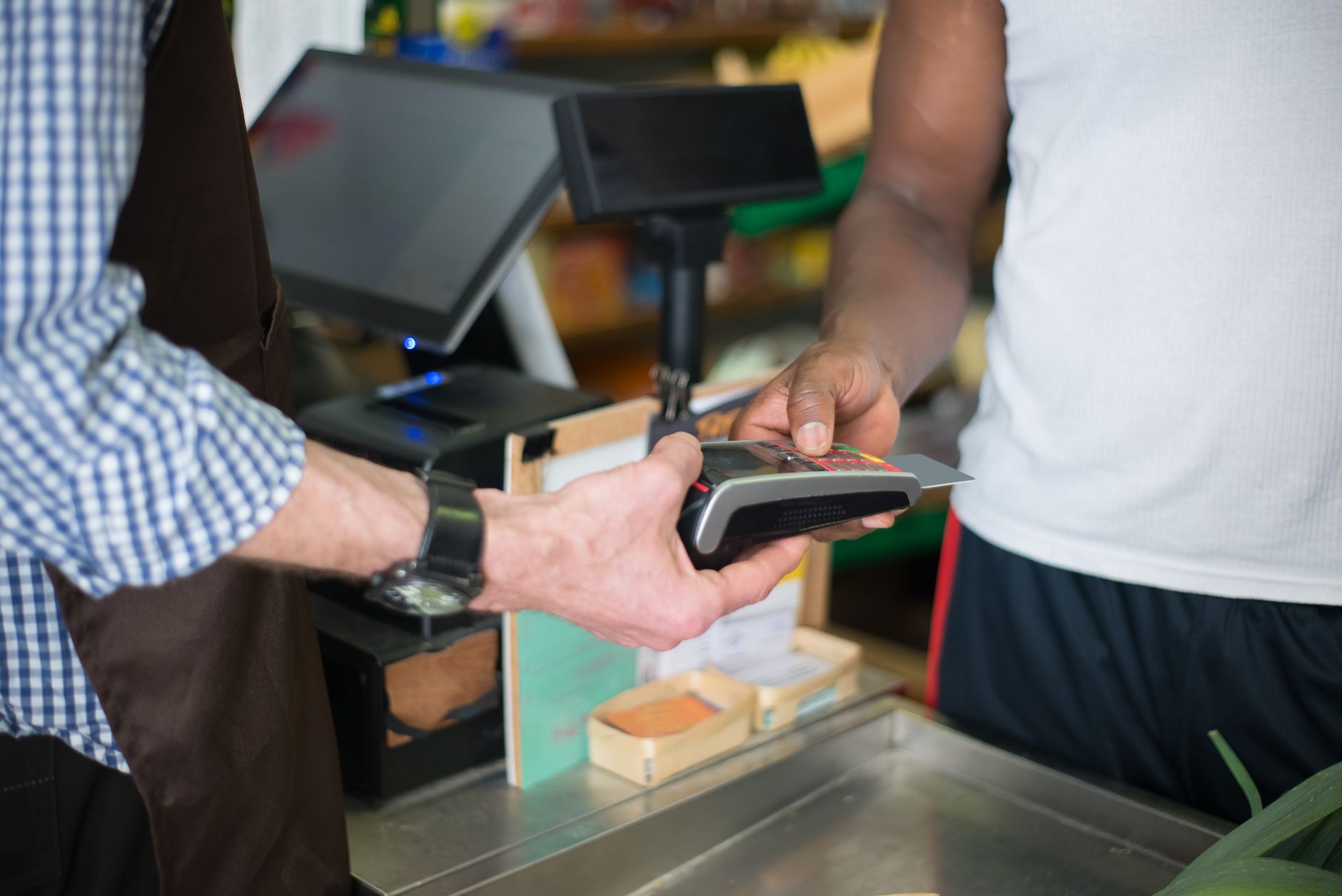 Cliente pagando con tarjeta en el mostrador de una tienda